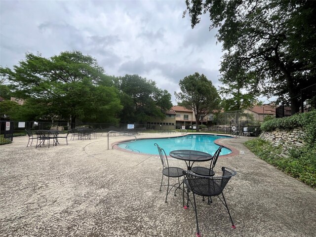 community pool featuring a patio area and fence