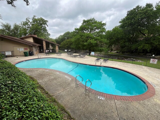 pool with fence and a patio