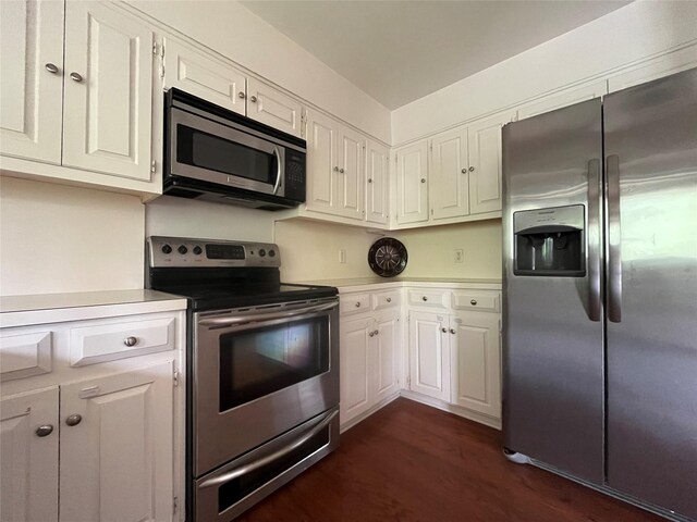 kitchen featuring light countertops, white cabinets, stainless steel appliances, and dark wood-type flooring