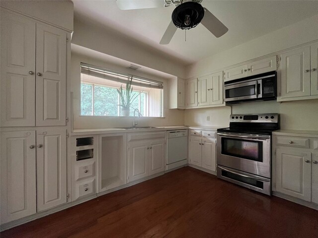 kitchen featuring dark wood-type flooring, light countertops, white cabinets, a sink, and appliances with stainless steel finishes