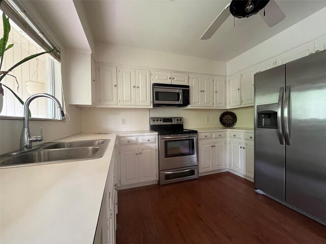kitchen with a sink, dark wood-style flooring, light countertops, a ceiling fan, and appliances with stainless steel finishes
