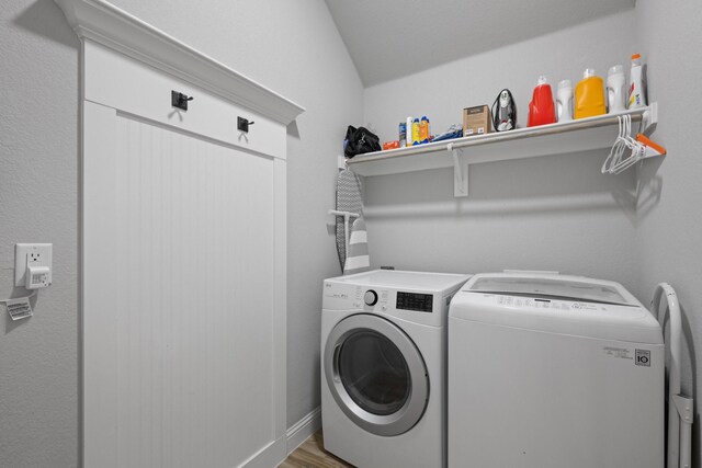 laundry room featuring laundry area, light wood-type flooring, and washer and clothes dryer