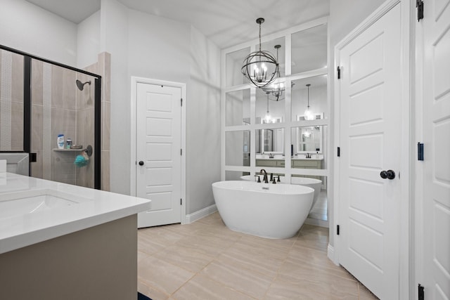 bathroom featuring an inviting chandelier, vanity, baseboards, a shower stall, and a soaking tub