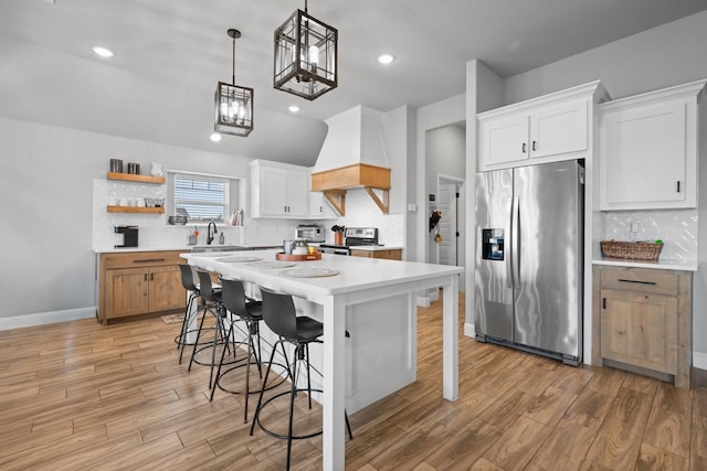 kitchen with light countertops, stainless steel appliances, custom exhaust hood, and light wood-style floors