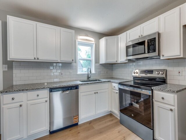 kitchen featuring a sink, white cabinetry, and appliances with stainless steel finishes