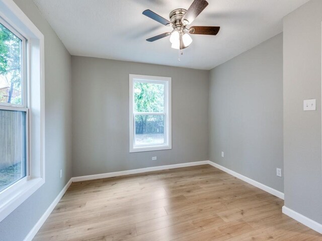 empty room featuring baseboards, light wood-style flooring, and ceiling fan