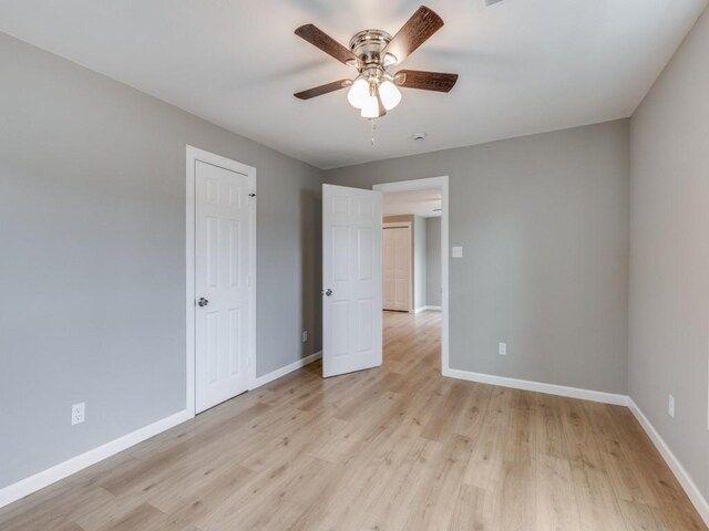 unfurnished bedroom featuring baseboards, ceiling fan, and light wood-style flooring