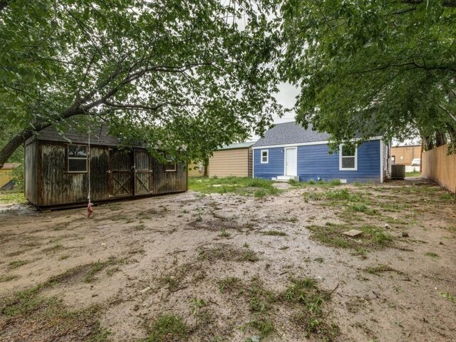 view of yard with fence and an outdoor structure