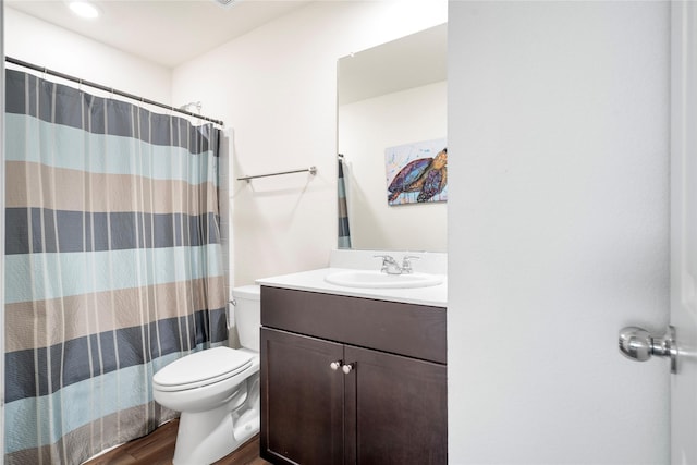 full bathroom with toilet, curtained shower, wood finished floors, and vanity