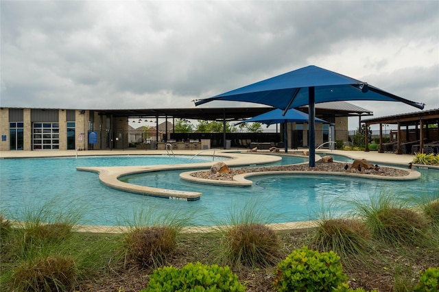 community pool featuring fence, a jacuzzi, and a patio area