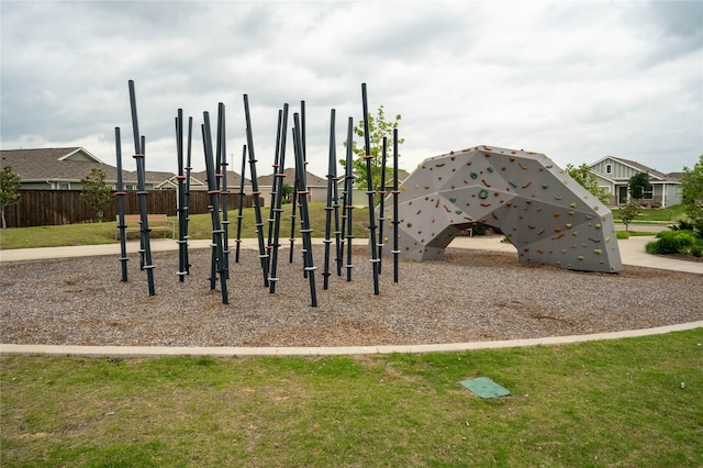 view of playground with a lawn and fence