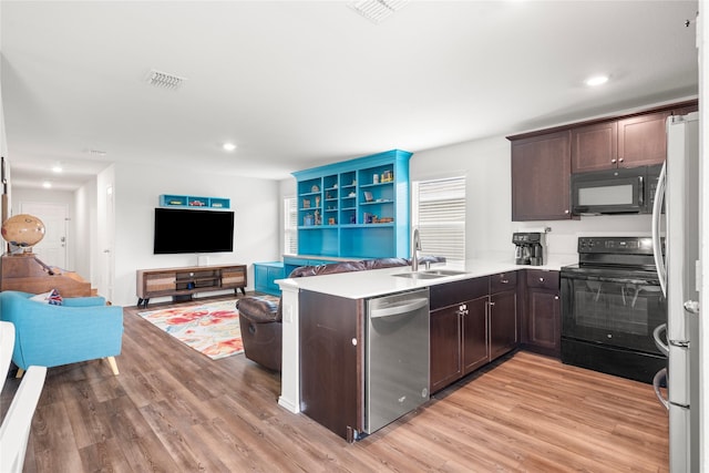 kitchen with a sink, light wood-style flooring, dark brown cabinetry, and black appliances