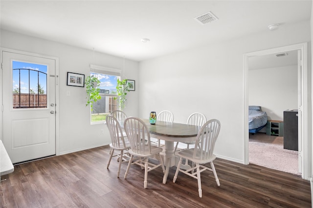 dining area featuring baseboards, visible vents, and dark wood-type flooring