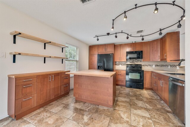 kitchen with decorative backsplash, wooden counters, a kitchen island, a sink, and black appliances