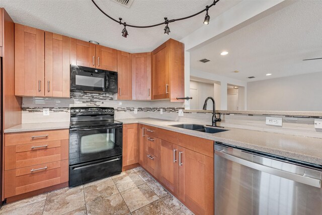 kitchen with decorative backsplash, visible vents, a sink, light countertops, and black appliances