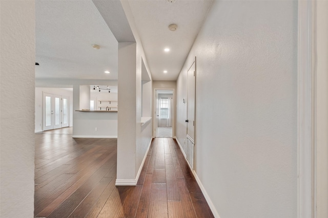 hall with baseboards, recessed lighting, and dark wood-style floors