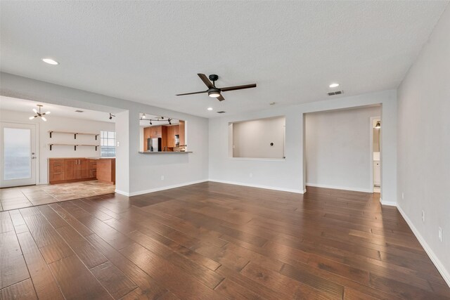 unfurnished living room with visible vents, a ceiling fan, a textured ceiling, and hardwood / wood-style floors