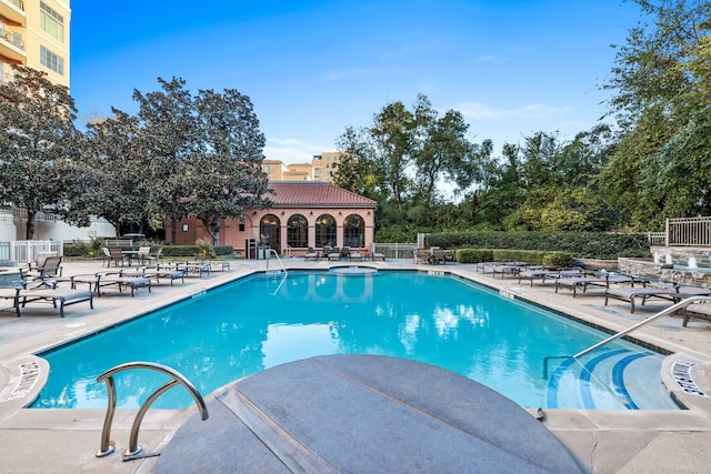 community pool with fence and a patio area