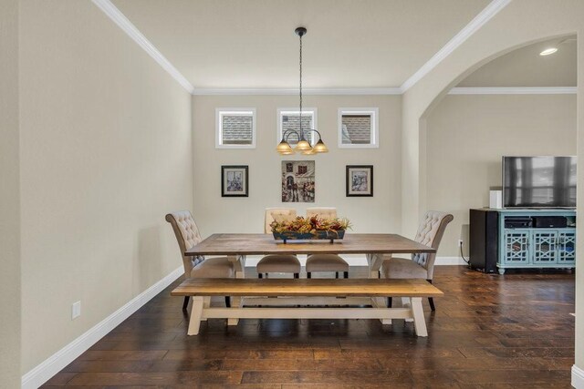 dining room featuring crown molding, arched walkways, baseboards, and hardwood / wood-style flooring