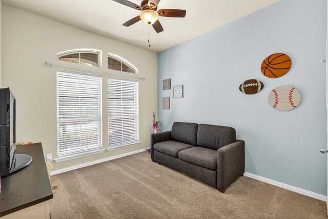 sitting room featuring a ceiling fan, a healthy amount of sunlight, and carpet