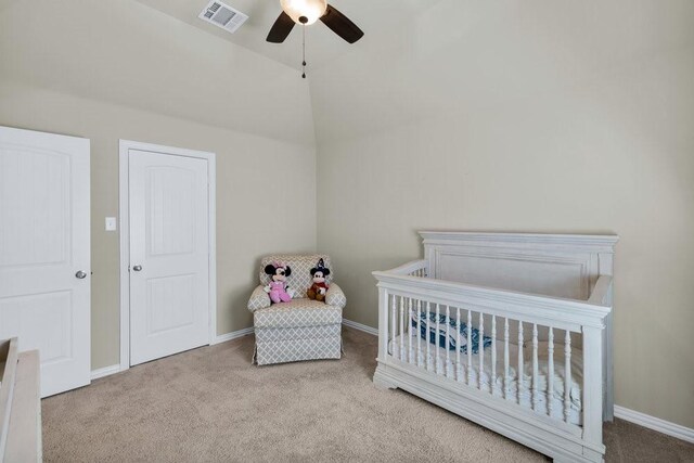 carpeted bedroom with a ceiling fan, visible vents, vaulted ceiling, baseboards, and a crib