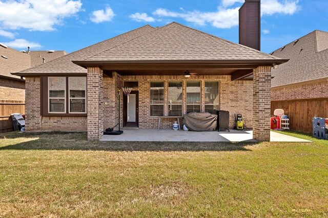 rear view of house with a patio, brick siding, and a fenced backyard