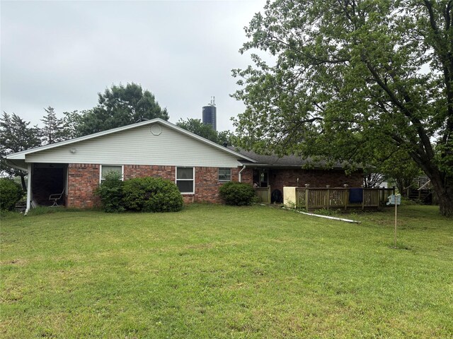 back of property featuring a lawn, brick siding, and a chimney