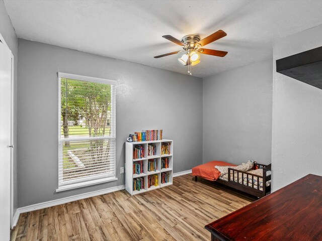 bedroom featuring a ceiling fan, baseboards, and wood finished floors