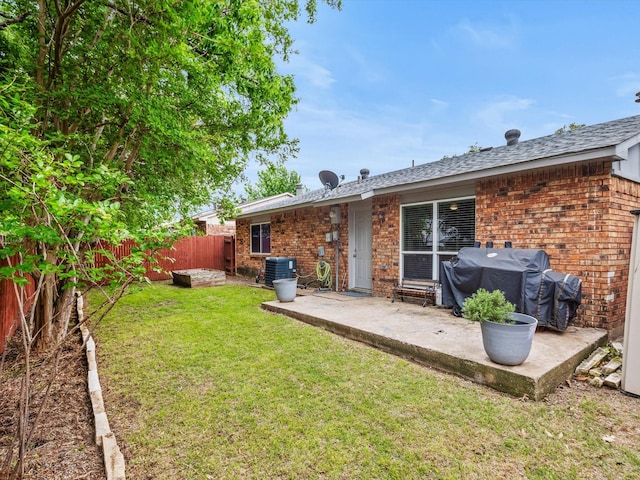 rear view of property featuring a patio, brick siding, central AC unit, and a fenced backyard