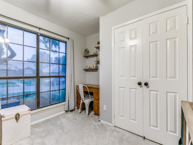 office with baseboards and light carpet