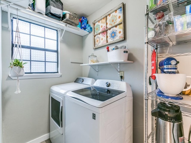 laundry area featuring washing machine and clothes dryer, laundry area, and baseboards