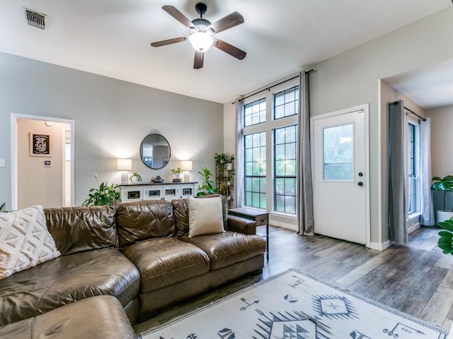 living area with ceiling fan, wood finished floors, and visible vents