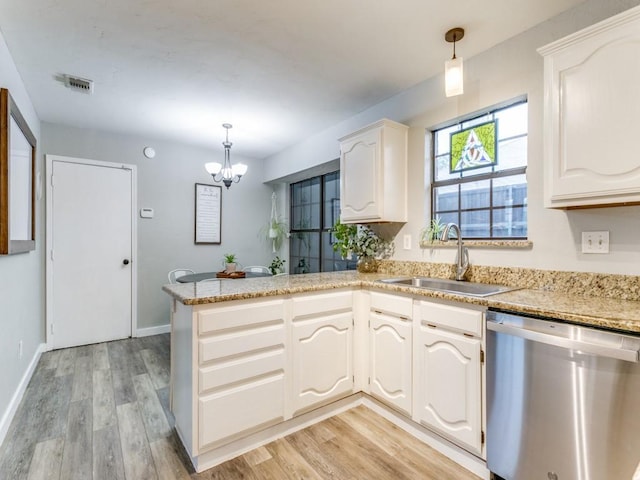 kitchen with visible vents, dishwasher, a sink, a peninsula, and an inviting chandelier