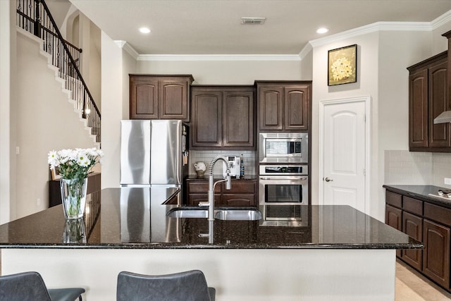 kitchen with dark brown cabinetry, appliances with stainless steel finishes, a sink, and visible vents