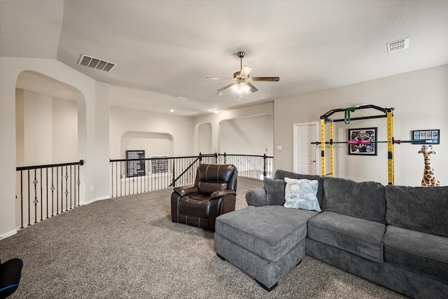 living room featuring visible vents, a ceiling fan, carpet floors, and arched walkways
