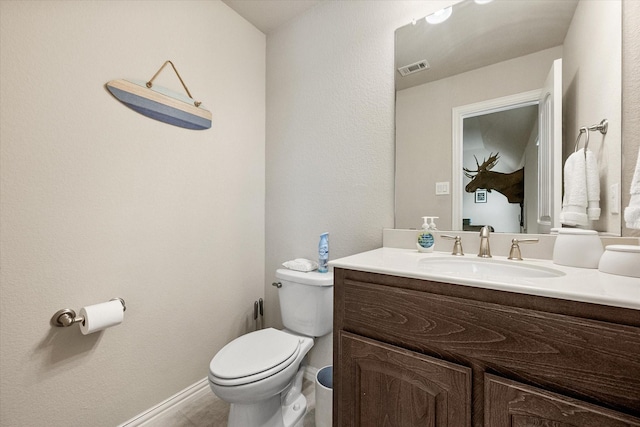 half bath featuring vanity, visible vents, and toilet