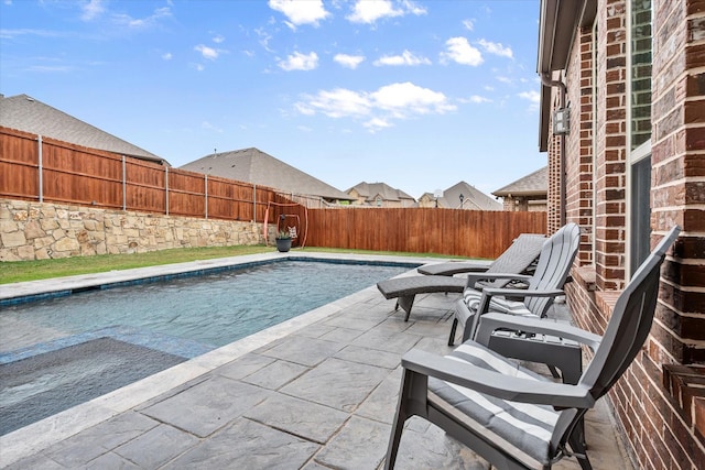 view of swimming pool featuring a patio, a fenced in pool, and a fenced backyard