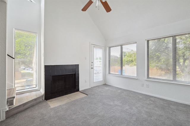 unfurnished living room with plenty of natural light, carpet, ceiling fan, and a fireplace
