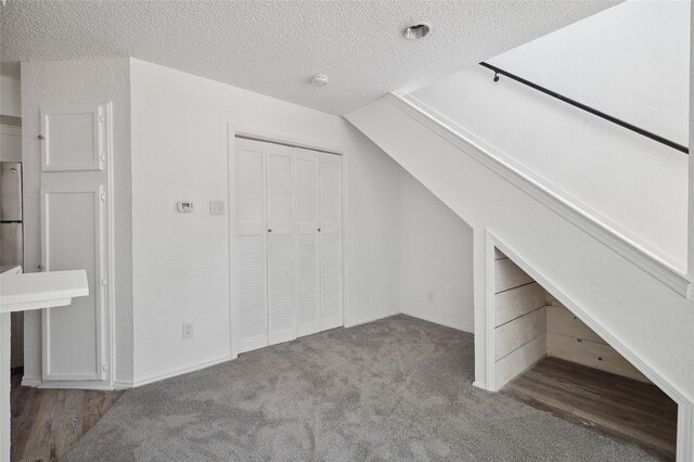 bonus room with carpet and a textured ceiling
