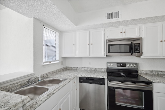 kitchen with visible vents, light countertops, white cabinets, a sink, and stainless steel appliances