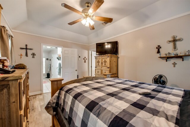 bedroom with light wood-style flooring, ceiling fan, and a tray ceiling