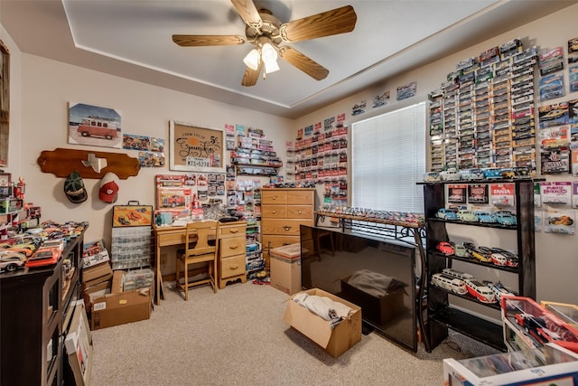 carpeted home office featuring a ceiling fan