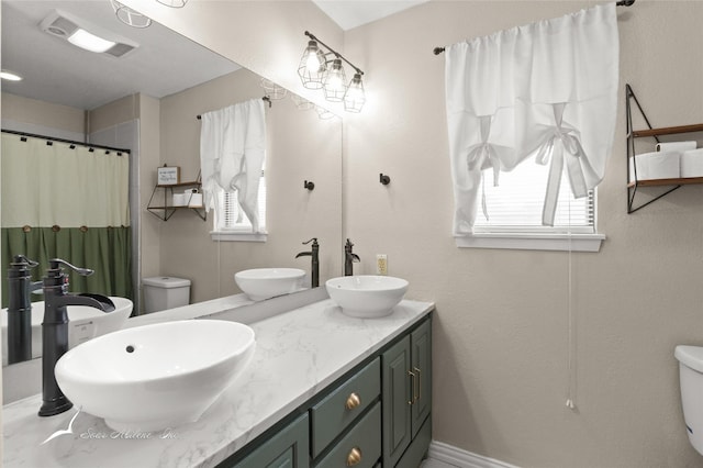 full bath featuring a sink, plenty of natural light, and toilet