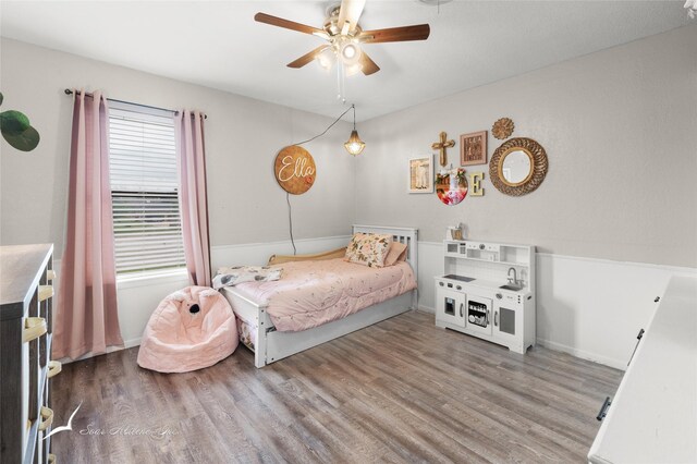 bedroom with baseboards, ceiling fan, and wood finished floors