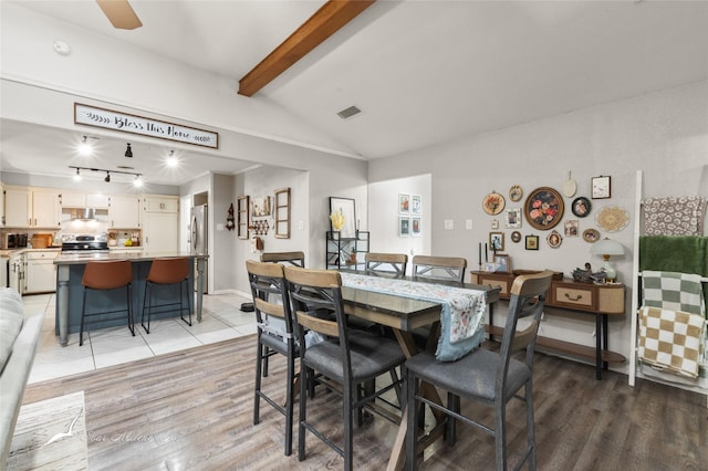 dining area with visible vents, track lighting, vaulted ceiling with beams, and light wood-type flooring