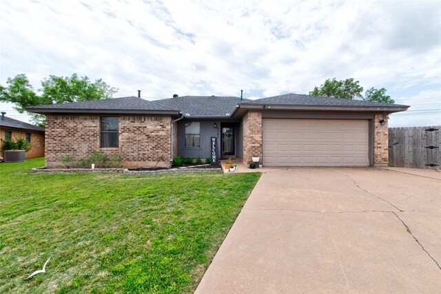 single story home with brick siding, a garage, a front yard, and concrete driveway