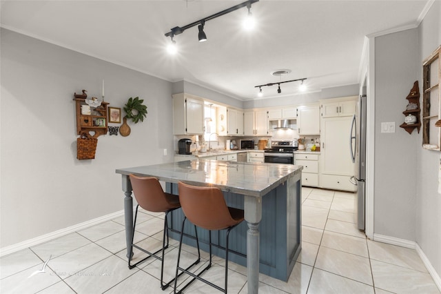 kitchen featuring stainless steel appliances, track lighting, a sink, and a peninsula