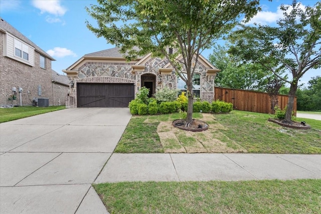 french country inspired facade with driveway, a front yard, fence, an attached garage, and stone siding
