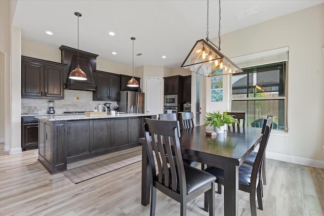 dining space with baseboards, recessed lighting, and light wood-style flooring