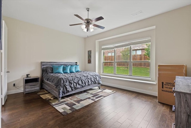 bedroom with baseboards, a ceiling fan, wood finished floors, and visible vents